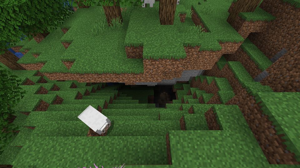 Screenshot of a cave entrance with a grassy floor